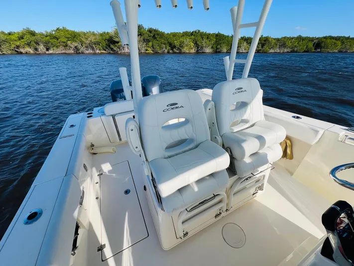  Yacht Photos Pics 2021 Cobia 301 Center Console boat with dual white seats on calm water.