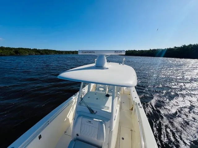  Yacht Photos Pics 2021 Cobia 301 Center Console boat on a sunny day, cruising on open water.
