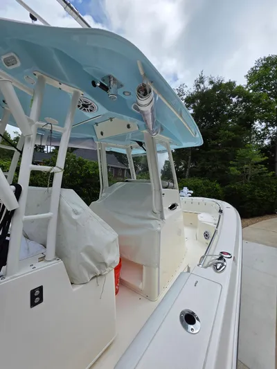  Yacht Photos Pics 2021 Cobia 301 Center Console boat with blue canopy, docked outdoors.