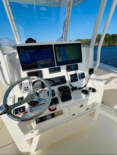  Yacht Photos Pics 2021 Cobia 301 Center Console boat dashboard with navigation screens and steering wheel.
