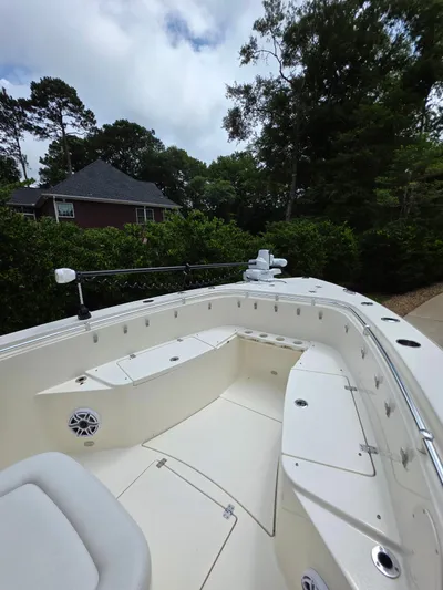  Yacht Photos Pics 2021 Cobia 301 Center Console boat with spacious seating, surrounded by lush greenery.