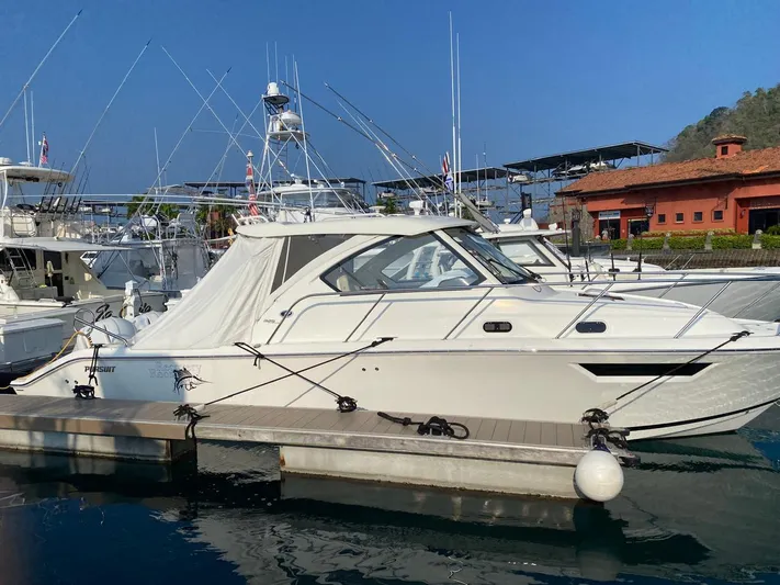 Recovery Room Yacht Photos Pics 2020 Pursuit OS 325 Offshore boat docked at marina under clear blue sky.