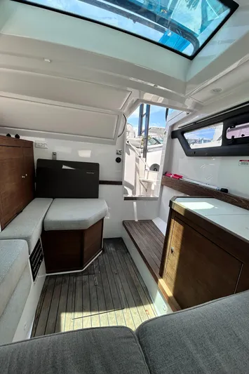 Yacht Photos Pics 2019 Axopar 37 Sun Top interior with seating, wood accents, and skylight.