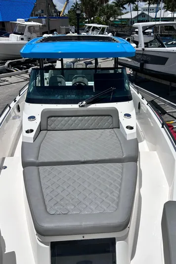  Yacht Photos Pics 2019 Axopar 37 Sun Top boat with blue roof and gray seating, docked at marina.