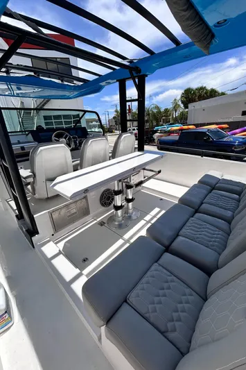 Yacht Photos Pics 2019 Axopar 37 Sun Top boat interior with seating and table under a blue canopy.