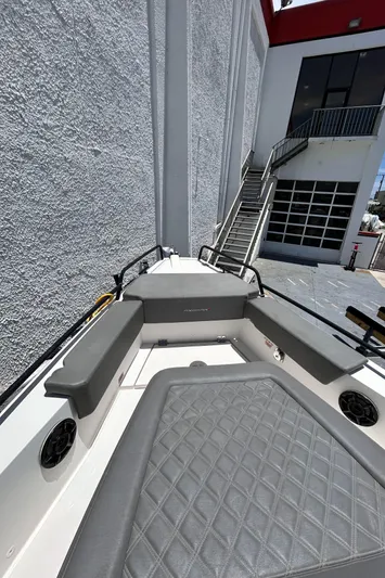  Yacht Photos Pics 2019 Axopar 37 Sun Top boat with gray seating, docked near a building.