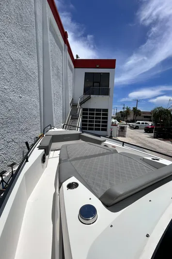  Yacht Photos Pics 2019 Axopar 37 Sun Top boat docked beside a white building under a clear blue sky.