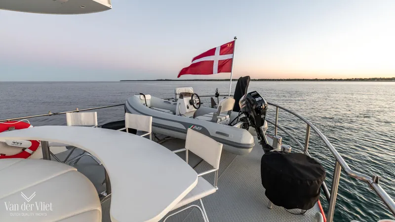  Yacht Photos Pics Altena Trawler 2009 yacht deck with Danish flag and seating area at sunset.