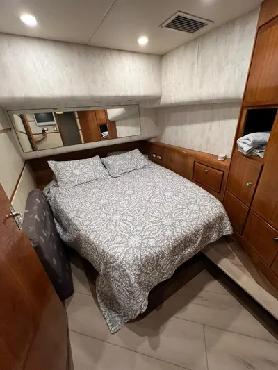 Play Pen Yacht Photos Pics Cozy bedroom in 2001 Bertram 510 Convertible yacht with patterned bedding and wooden cabinetry.