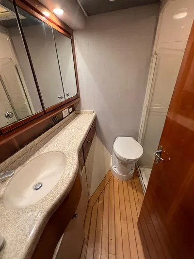 Play Pen Yacht Photos Pics Bathroom interior of a 2001 Bertram 510 Convertible yacht with wooden flooring.
