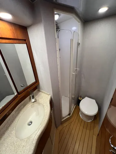 Play Pen Yacht Photos Pics 2001 Bertram 510 Convertible yacht bathroom with shower, sink, and toilet.