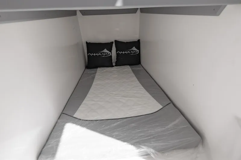  Yacht Photos Pics Compact sleeping area in 2025 Streamline R 35 with pillows and bedding.