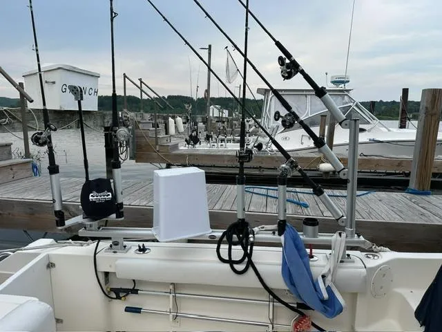  Yacht Photos Pics 2003 Pursuit 3070 Express boat with fishing rods docked at marina.