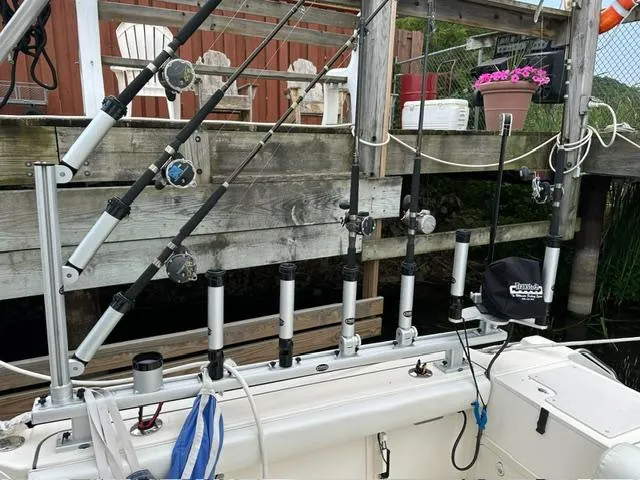  Yacht Photos Pics Fishing rods on a 2003 Pursuit 3070 Express boat docked near wooden pier.