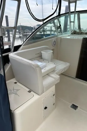  Yacht Photos Pics 2003 Pursuit 3070 Express boat interior with white seating and marina view.
