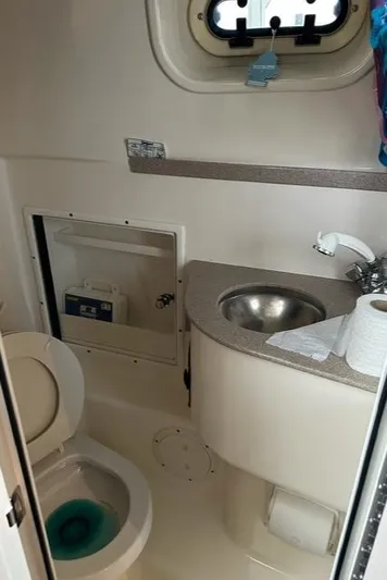  Yacht Photos Pics Compact bathroom in a 2003 Pursuit 3070 Express boat, featuring a toilet and sink.