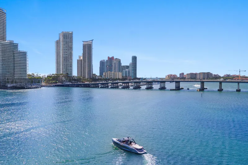 Mischief Yacht Photos Pics Boat cruising near city skyline and bridge, featuring a 2020 Princess R35 model.