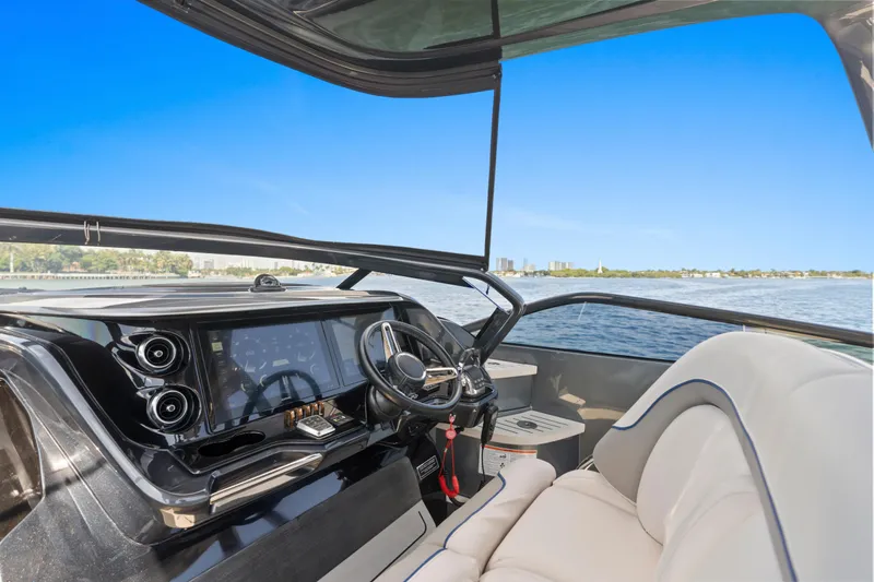 Mischief Yacht Photos Pics Luxurious 2020 Princess R35 yacht interior with modern dashboard and scenic water view.