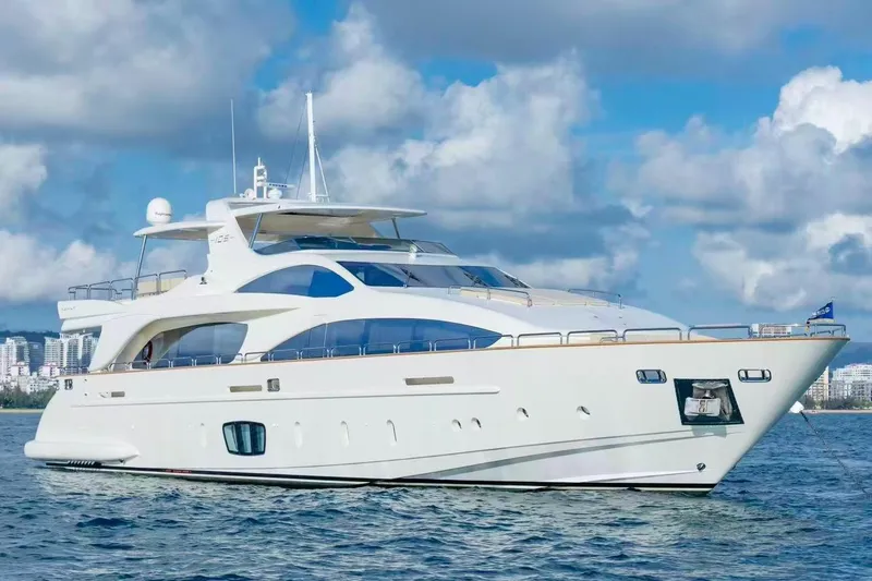  Yacht Photos Pics Luxurious 2010 Azimut 105 yacht cruising on a sunny day with city skyline backdrop.