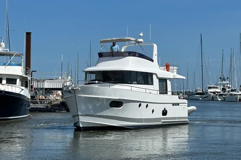 Smooth Yacht Photos Pics 2019 Beneteau Swift Trawler 50 in marina, surrounded by other boats.