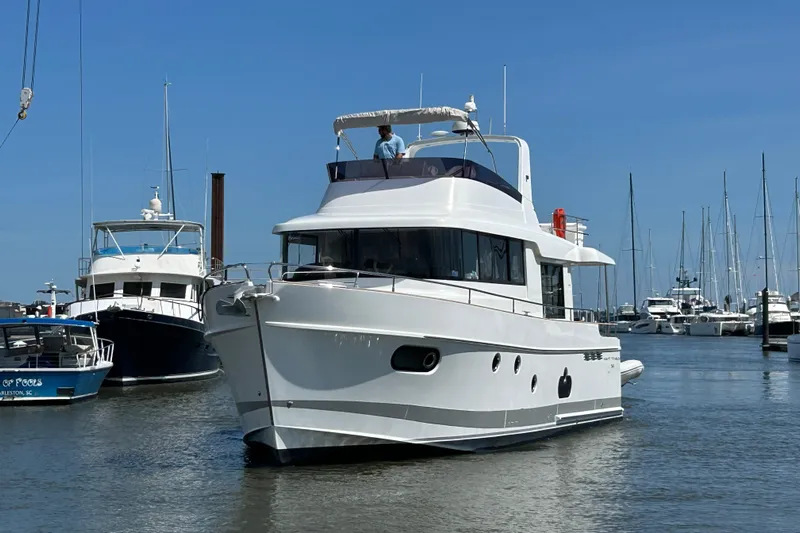 Smooth Yacht Photos Pics 2019 Beneteau Swift Trawler 50 docked in a marina under clear blue skies.