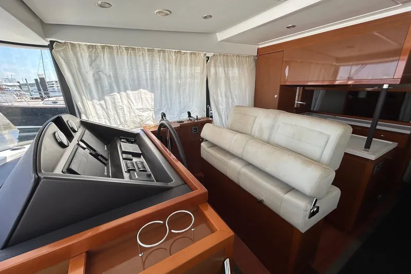 Smooth Yacht Photos Pics 2019 Beneteau Swift Trawler 50 interior with helm, seating, and wooden cabinetry.