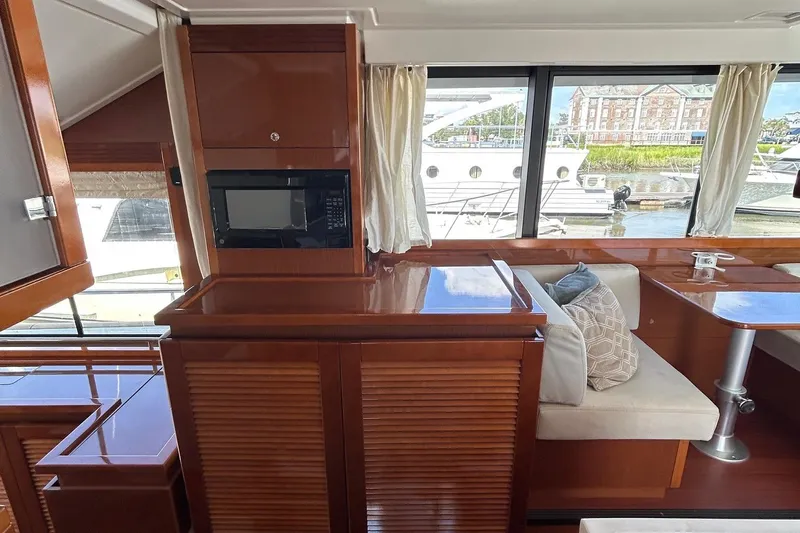 Smooth Yacht Photos Pics 2019 Beneteau Swift Trawler 50 interior with wood finish, seating, and large windows.