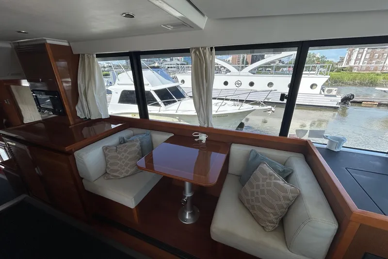 Smooth Yacht Photos Pics Interior of 2019 Beneteau Swift Trawler 50 with cozy seating and marina view.