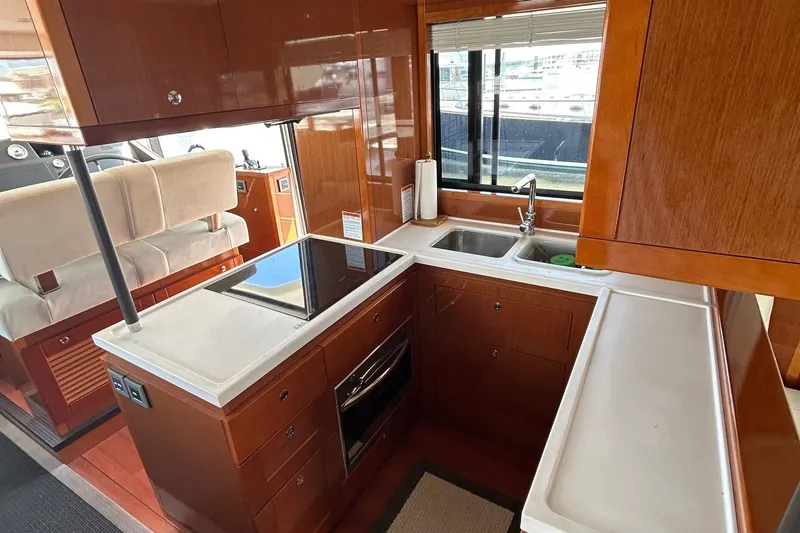 Smooth Yacht Photos Pics 2019 Beneteau Swift Trawler 50 kitchen with modern appliances and wooden cabinetry.
