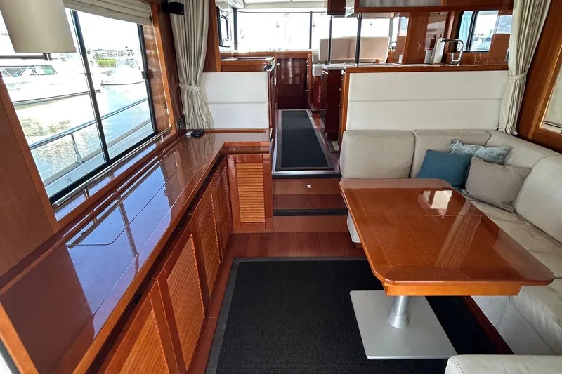 Smooth Yacht Photos Pics Interior of 2019 Beneteau Swift Trawler 50, featuring elegant wood finishes and comfortable seating.