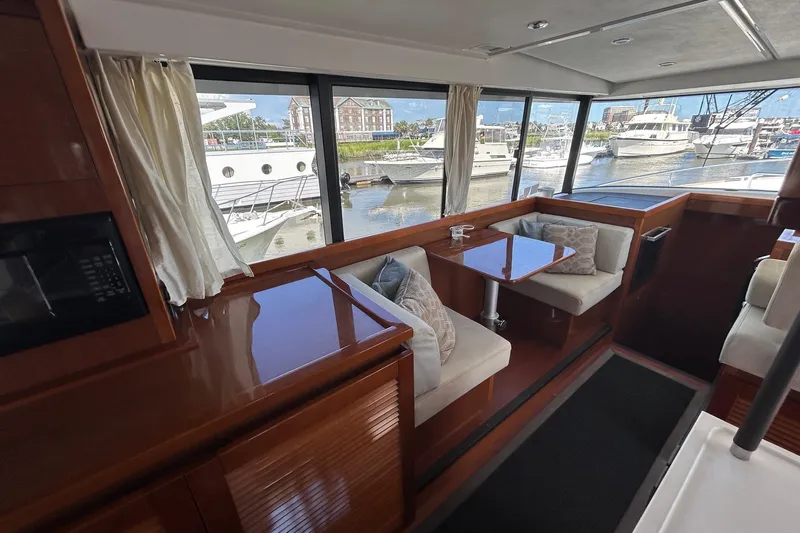Smooth Yacht Photos Pics Interior of 2019 Beneteau Swift Trawler 50 with seating and waterfront view.