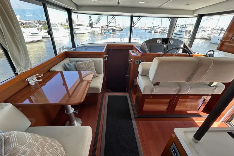 Smooth Yacht Photos Pics 2019 Beneteau Swift Trawler 50 interior with helm, seating, and dining area.