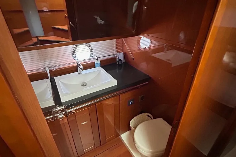 Smooth Yacht Photos Pics 2019 Beneteau Swift Trawler 50 bathroom with sink, toilet, and porthole window.