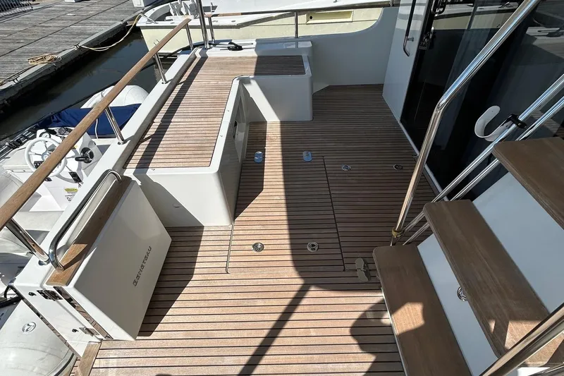 Smooth Yacht Photos Pics 2019 Beneteau Swift Trawler 50 deck with wooden flooring and stainless steel railings.