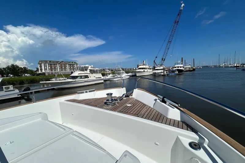 Smooth Yacht Photos Pics 2019 Beneteau Swift Trawler 50 docked at a marina under a clear blue sky.