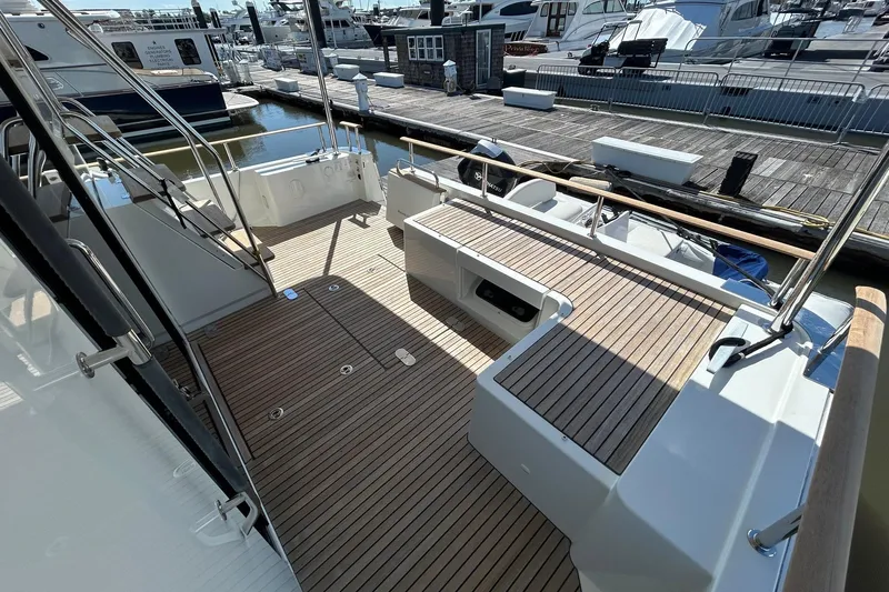 Smooth Yacht Photos Pics 2019 Beneteau Swift Trawler 50 deck with wood finish, docked at marina.