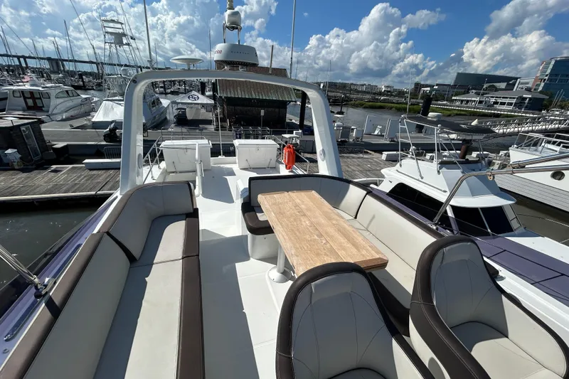 Smooth Yacht Photos Pics 2019 Beneteau Swift Trawler 50, spacious deck with seating and table, docked at marina.