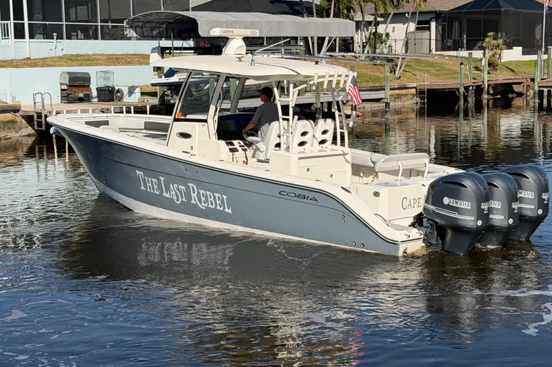  Yacht Photos Pics 2016 Cobia 344 Center Console boat with triple Yamaha engines on a calm waterway.
