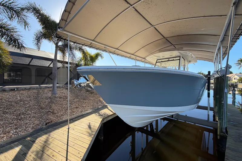  Yacht Photos Pics 2016 Cobia 344 Center Console boat docked under canopy with palm trees.