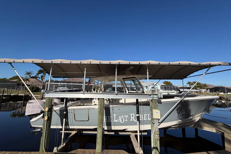  Yacht Photos Pics 2016 Cobia 344 Center Console boat docked with canopy, named "The Last Rebel."