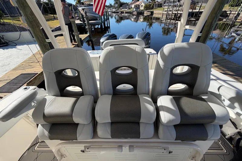  Yacht Photos Pics 2016 Cobia 344 Center Console boat seats by a dockside canal.