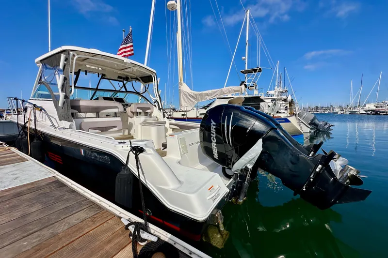Seahorse Yacht Photos Pics 2018 Wellcraft 290 Coastal boat docked, featuring Mercury outboard engine, clear blue sky.