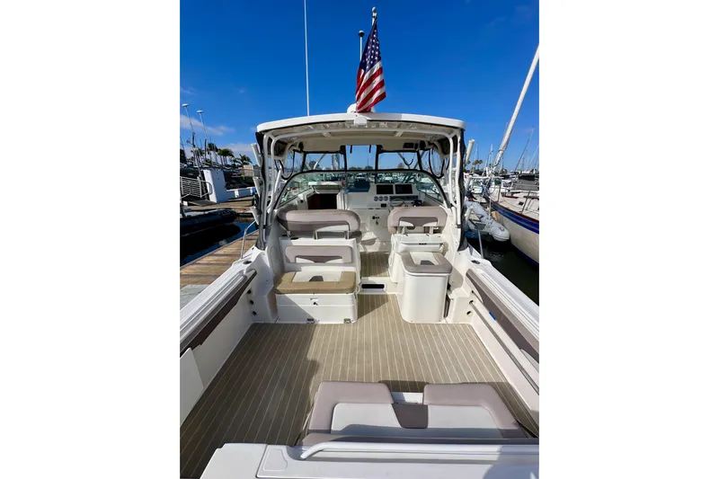 Seahorse Yacht Photos Pics 2018 Wellcraft 290 Coastal boat interior with seating, docked at marina under clear blue sky.