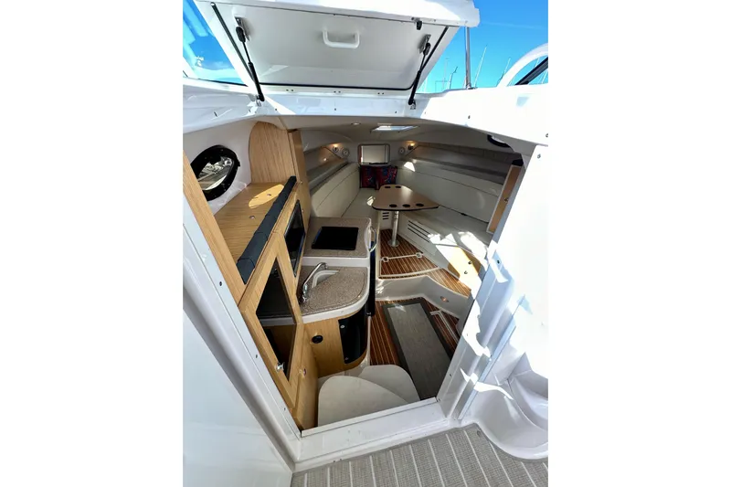 Seahorse Yacht Photos Pics 2018 Wellcraft 290 Coastal cabin interior with kitchenette and seating area.