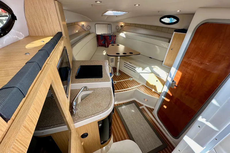 Seahorse Yacht Photos Pics 2018 Wellcraft 290 Coastal cabin interior with kitchenette, seating, and wooden accents.