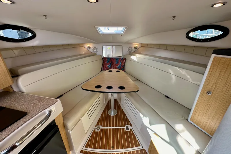 Seahorse Yacht Photos Pics 2018 Wellcraft 290 Coastal cabin interior with seating, table, and wood accents.