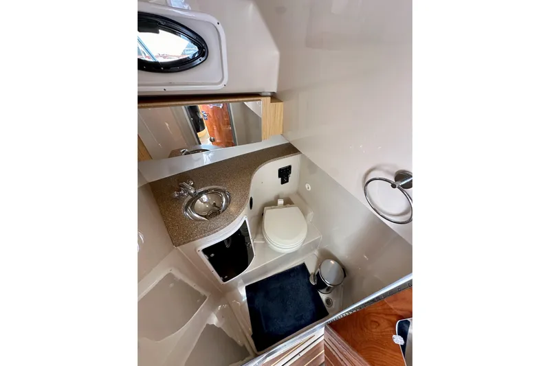 Seahorse Yacht Photos Pics 2018 Wellcraft 290 Coastal boat bathroom with sink, toilet, and mirror.
