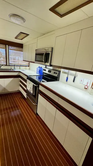 Adventurer Yacht Photos Pics Modern kitchen interior on 1987 Burger 86 Raised Pilothouse yacht, featuring sleek cabinetry and appliances.