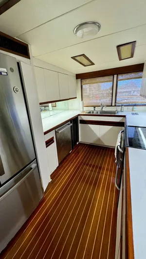 Adventurer Yacht Photos Pics Luxurious kitchen interior of 1987 Burger 86 Raised Pilothouse yacht with wood flooring.