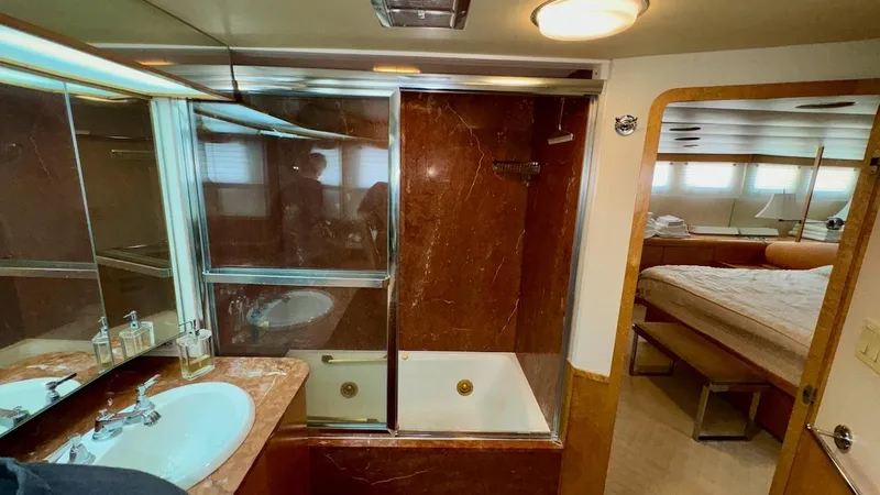 Adventurer Yacht Photos Pics Luxurious bathroom in 1987 Burger 86 Raised Pilothouse yacht with marble accents and spacious layout.